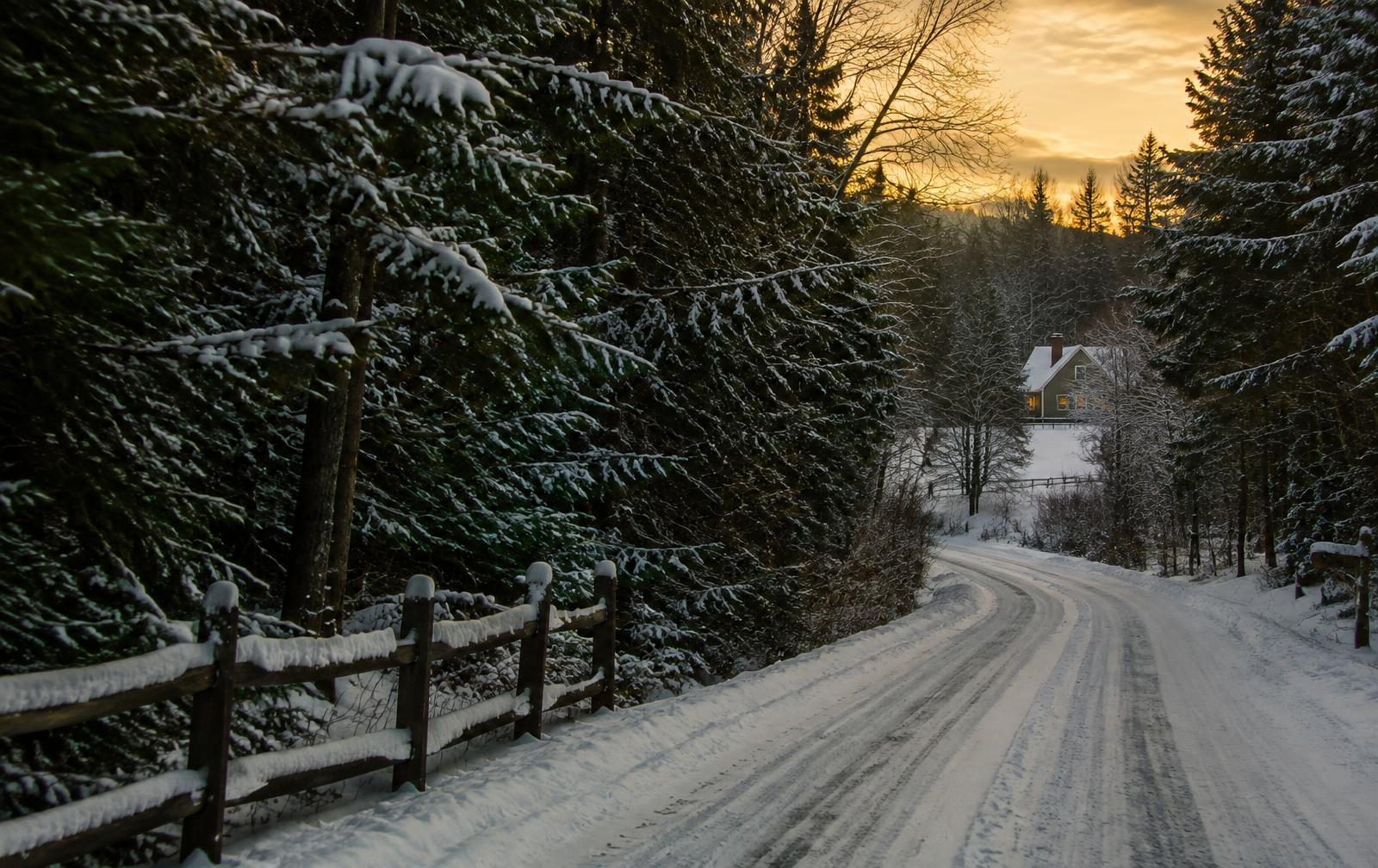 Snowy country road through the Maine woods at dusk